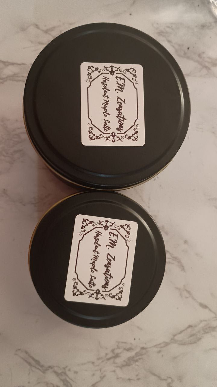 Hazelnut Maple Latte coffee containers with decorative labels on a marble surface.